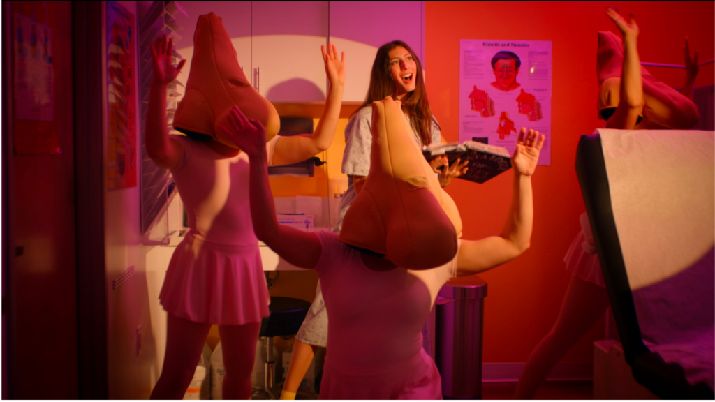 Image of Catalogue of Noses writer Lauren Schaffel dancing with "nose characters" in screen shot from film